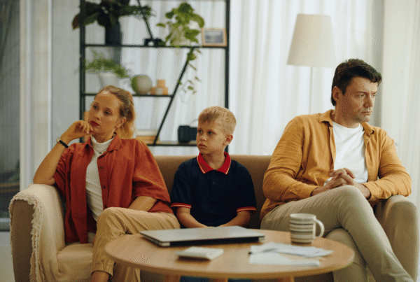 Child Sitting Between Divorced Parents